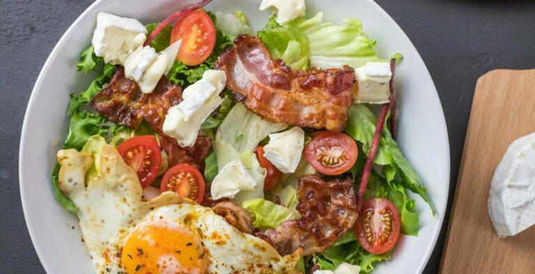 Fresh ketogenic salad with bacon, egg, feta, and tomatoes, perfect for healthy eating.